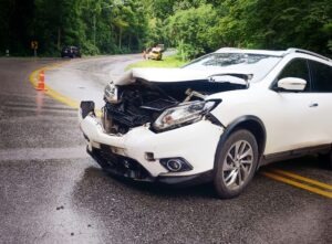 A white car damaged on the road after an accident that stays on your record in FL